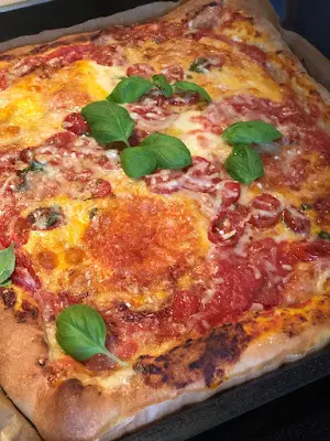 Pizza mit Käserand, Mozzarella und Basilikum